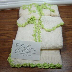 Vintage novelty dishcloths with crocheted edges folded to resemble baby items